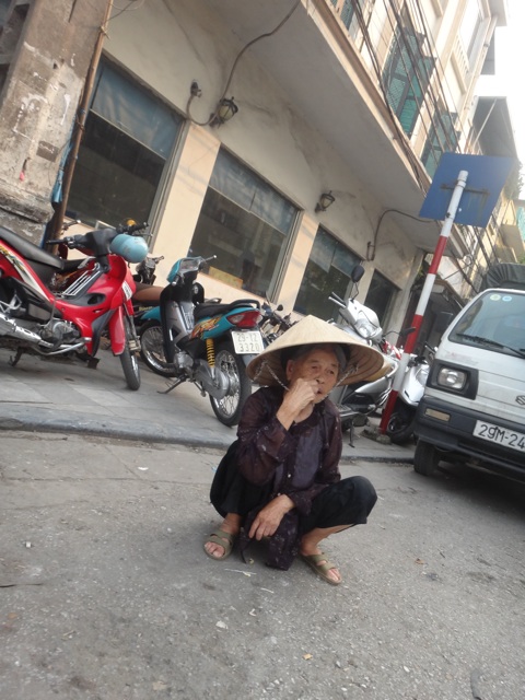 Une femme accroupie dans la rue