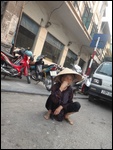 Une femme accroupie dans la rue